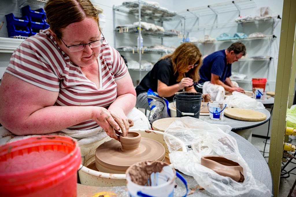 Students working at pottery wheels in a studio